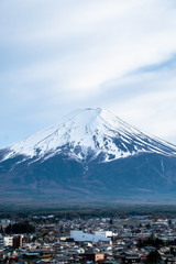 Close up Fuji Mountain in vertical against blue clods sky background ,cityscape view in front in Japan.