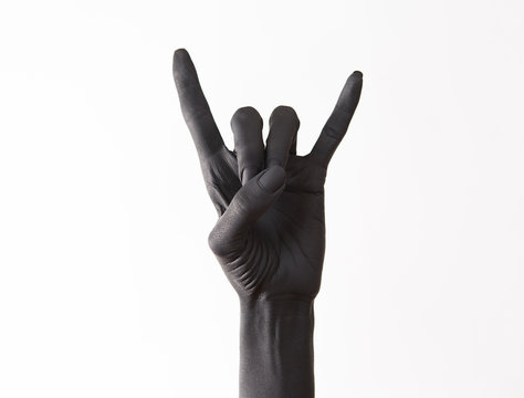 Goat gesture on a dark background. Black hand doing rock symbol. Hands up