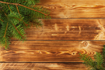 Christmas background of fir tree branches on an old vintage wooden board, copy space for text, top view.
