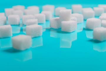 selective focus Group of Sugar cubes vary position on light blue background