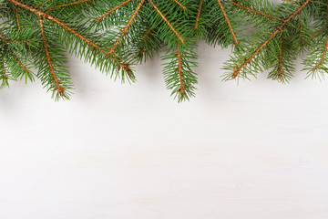 Christmas background of fir tree branches on white  wooden board, copy space for text, top view.
