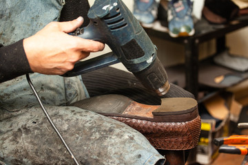 Obraz premium close up of the hands of a man repairing shoes