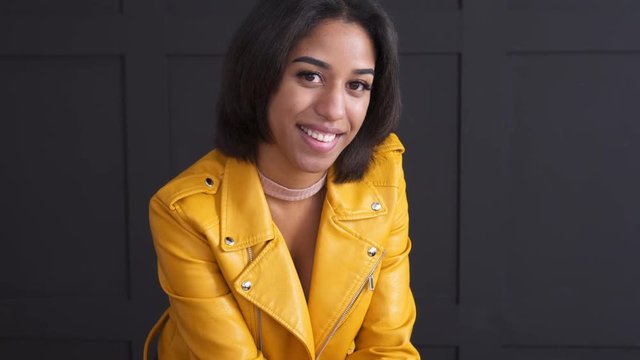 Teenage girl smiling in yellow leather jacket