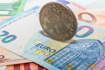 half crown coin on top of euros banknotes