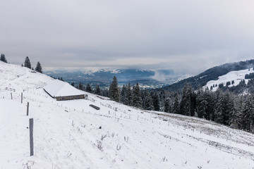 Fototapeta na wymiar snowy winter landscape in the Gurnigel Area, Berner Oberland with the Thunersee in the distance