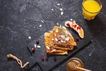 Traditional crepes with banana and berries on stone background