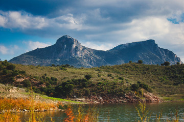 Rocky mountain landscape above a serene lake at Zahara de la Sierra, Anadalucia