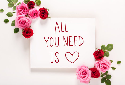All You Need Is Love message with roses and leaves top view flat lay