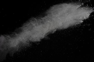 White powder explosion isolated on black background.
