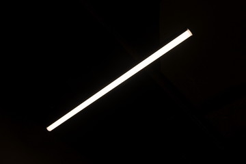 neon white light on ceiling in dark room