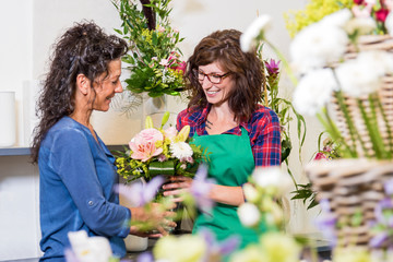 Lächelnde Floristin verkauft einer Kundin einen Blumenstrauss