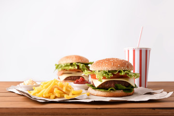 Two burger with soda and chips with souces white background
