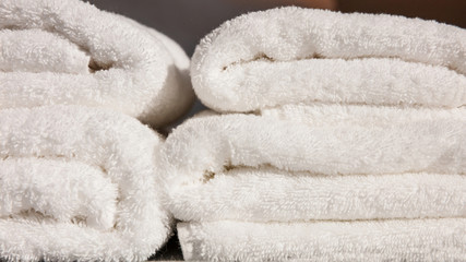 Stack of white folded towels background. Closeup view with details