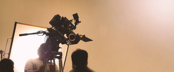 Behind the shooting or filming video movie and film production crew team setting up camera on...
