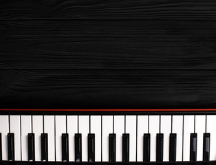 synthesizer keyboard on black wooden background
