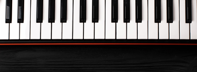 synthesizer keyboard on black wooden background