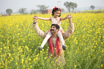 Portrait of happy rural family in rapeseed agricultural field