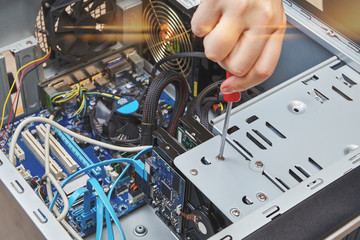 Repairman is installing HDD of desktop computer.