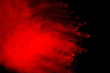 Red powder explosion isolated on black background.