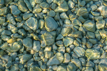 Sea stones background and light from the sun on the stones. Abstract art for background . Sun glare...