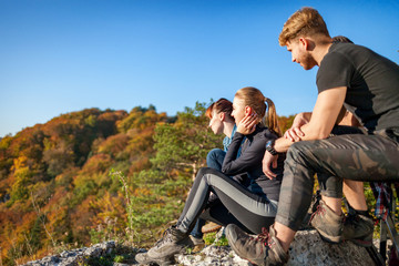 Group of travelers sitting on rock and resting after trekking in mountain