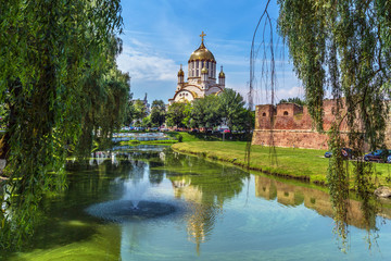 Fototapeta na wymiar Nice scenario with a tall church and a lake with trees around in Romania