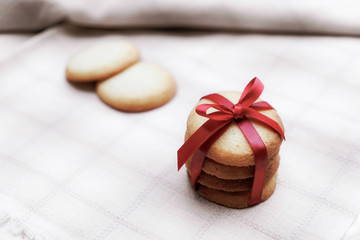 Many pieces of cookies bind a red bow on the fabric.