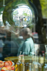 Reflection of the street in a mirror ball hanging in a glass window