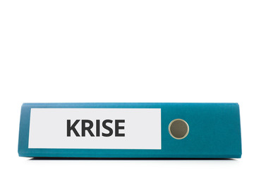 blauer liegender Aktenordner mit Beschriftung krise vor hellem Hintergrund