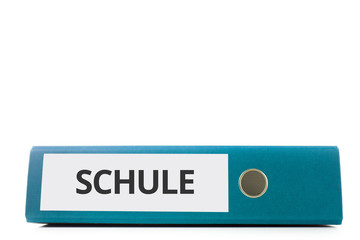 blauer liegender Aktenordner mit Beschriftung Schule vor hellem Hintergrund