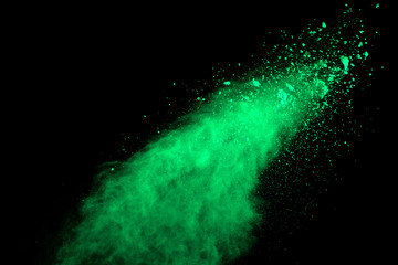 Green powder explosion on black background. Colored cloud. Colorful dust explode. Paint Holi.