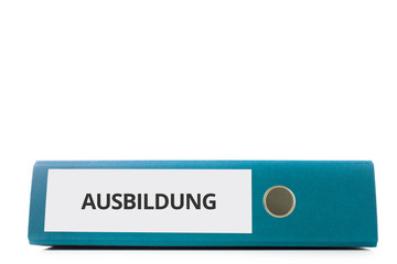 blauer liegender Aktenordner mit Beschriftung Ausbildung vor hellem Hintergrund