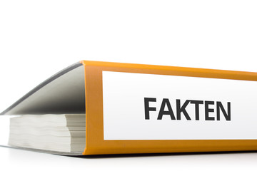 oranger Aktenordner gefüllt mit Papierseiten und Beschriftung Fakten liegend vor weißem...