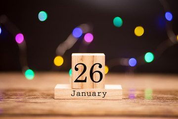 Naklejka premium January 26th. Day 26 of month at center of dark background with garland bokeh. Winter time, year concept.