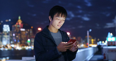 Man use of mobile phone in city at night