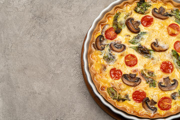 Baked homemade quiche pie in ceramic baking form