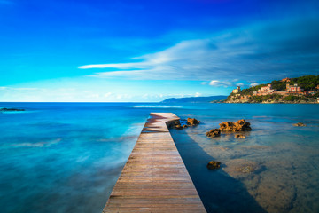 Fototapeta na wymiar Castiglioncello bay wooden pier, rocks and sea. Tuscany, Italy.