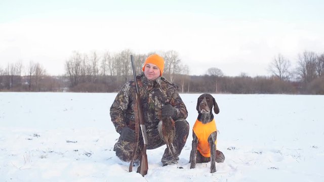 hunter likes his dog. handsome man looking at his tired dog after hunting.