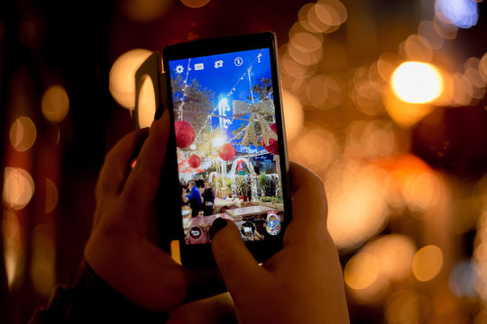 A person captures Christmas decorations on smartphone