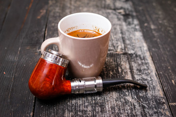 Electronic pipe, advanced personal vaporizer, e-cigarette mod and cup of coffee on rustic wooden table