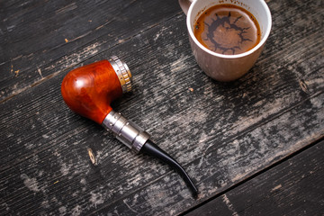 Electronic pipe, advanced personal vaporizer, e-cigarette mod and cup of coffee on rustic wooden table