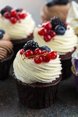 Various sweet cupcakes on brown stone background. 