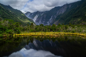 Naklejka na ściany i meble New Zealand tourist popular attractions/destinations concept. Scenic landscape view of valley and Franz Josef Glacier in summer season, located at West Coast, South Island. 
