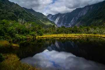 New Zealand tourist popular attractions/destinations concept. Scenic landscape view of valley and Franz Josef Glacier in summer season, located at West Coast, South Island. 