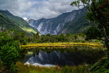 New Zealand tourist popular attractions/destinations concept. Scenic landscape view of valley and Franz Josef Glacier in summer season, located at West Coast, South Island. 
