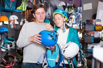 Girl and the guy choosing mountaineering equipment