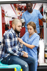 Paramedic team  providing first aid to man