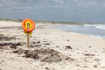 Old lifebuoy on the dirty sandy beach on the Cozumel island. Mexico