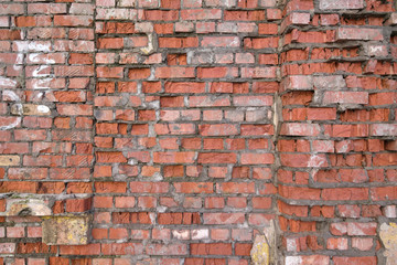 Collapsing old wall of red broken bricks, background and texture