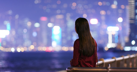 Woman look arond and far away in the city at night